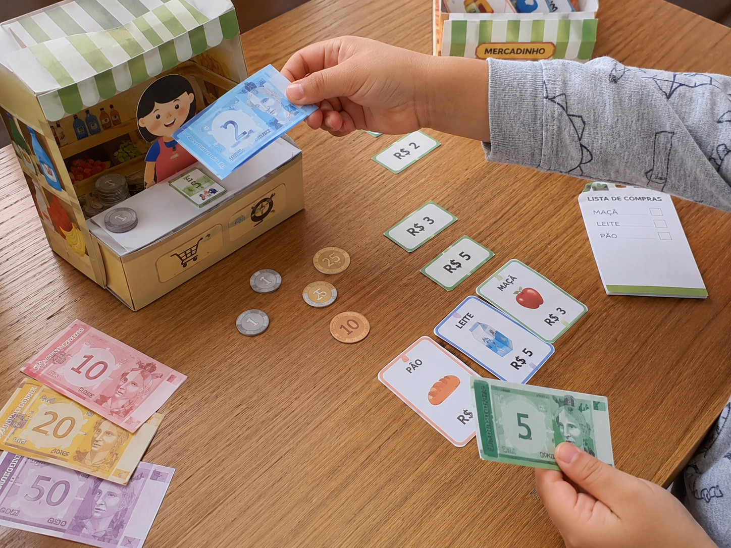 Criança brincando de mercadinho com o dinheiro de papel